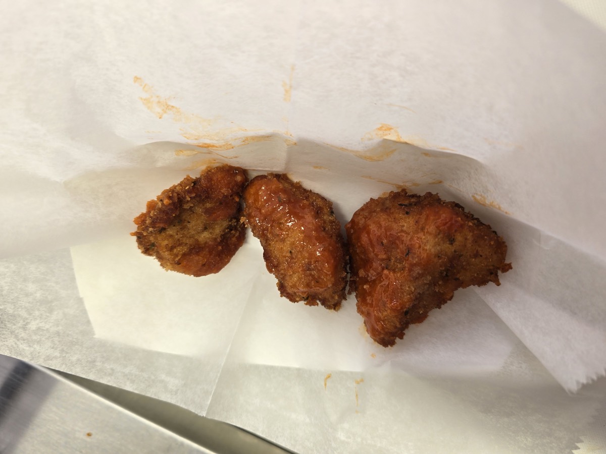 Golden hand-breaded chicken breast bites on parchment paper